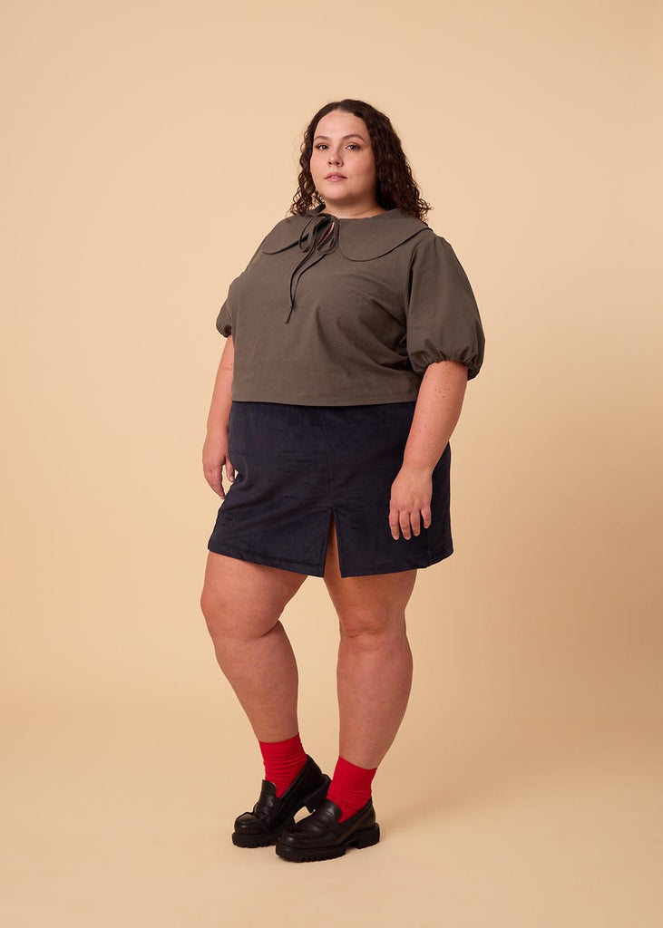 a plus size woman wearing a navy miniskirt