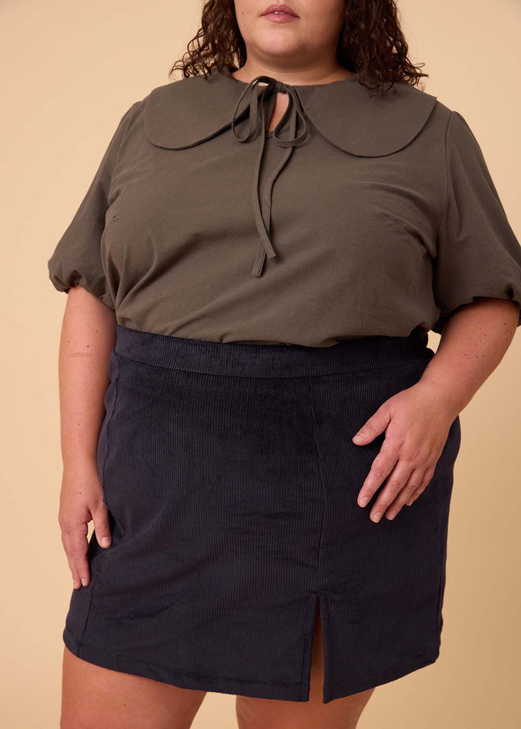 a close up of a plus size woman wearing a navy miniskirt