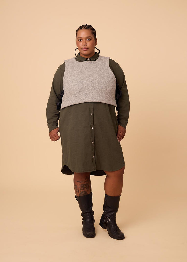 a plus size woman wearing a grey wool vest