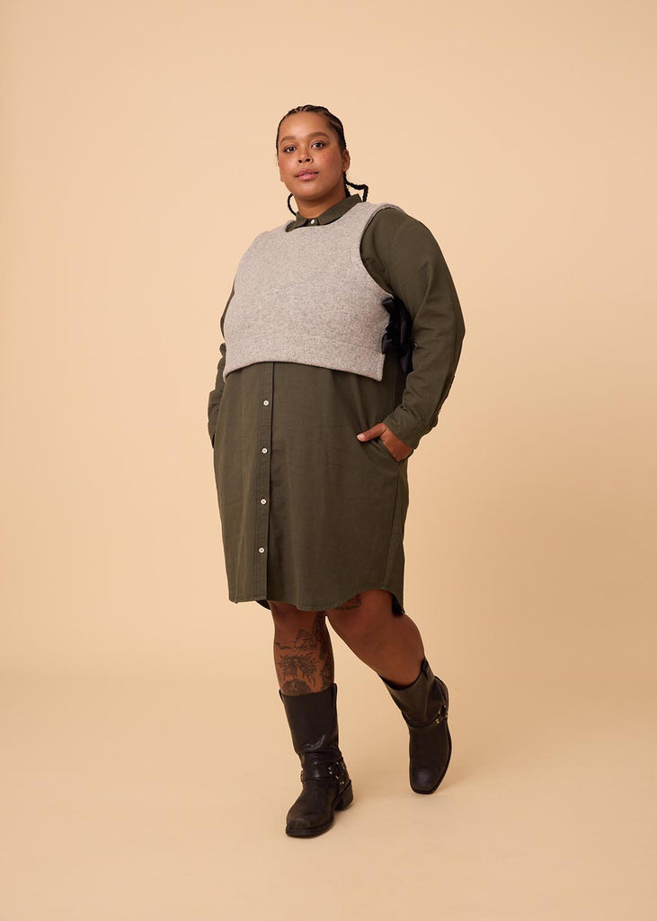 plus size person in an olive green shirt dress with a grey vest