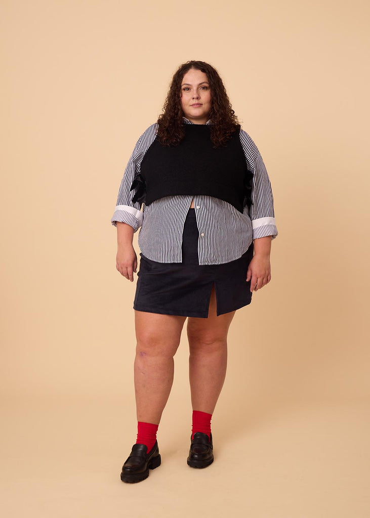 a plus size woman wearing a black wool vest