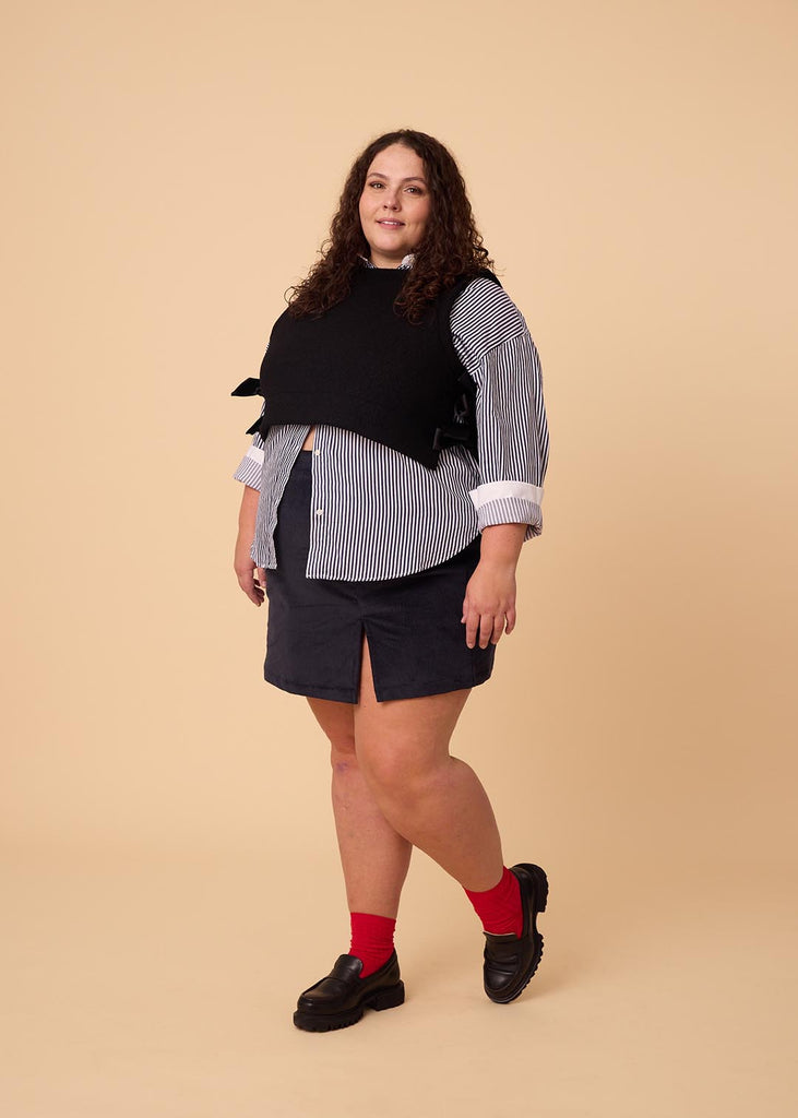 a plus size woman wearing a navy miniskirt