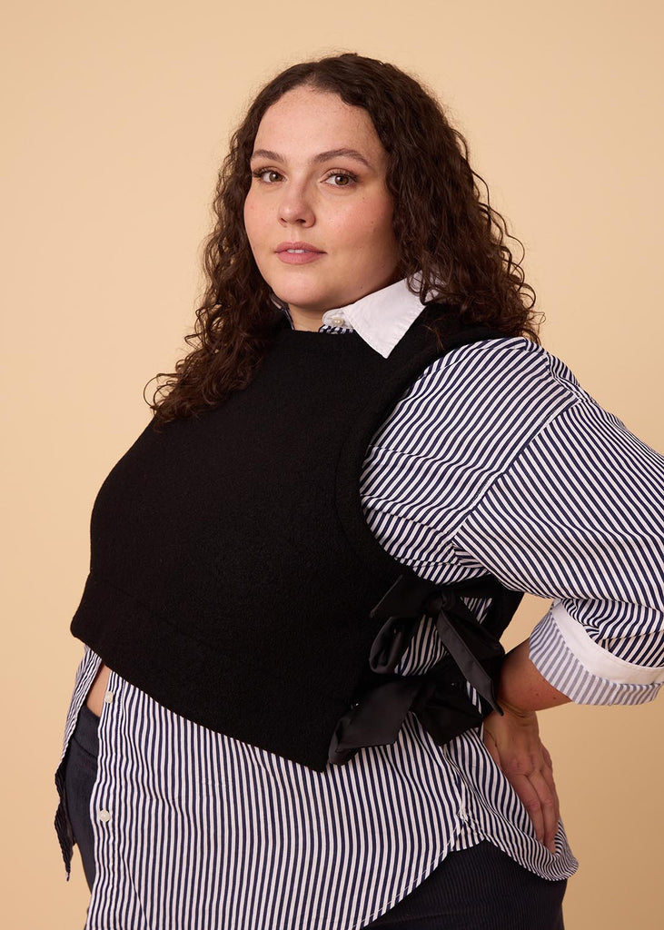 a plus size woman wearing a black wool vest