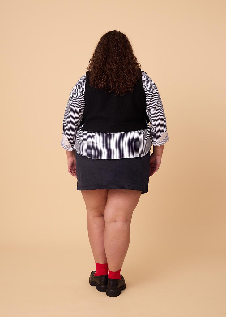 a plus size woman wearing a navy miniskirt