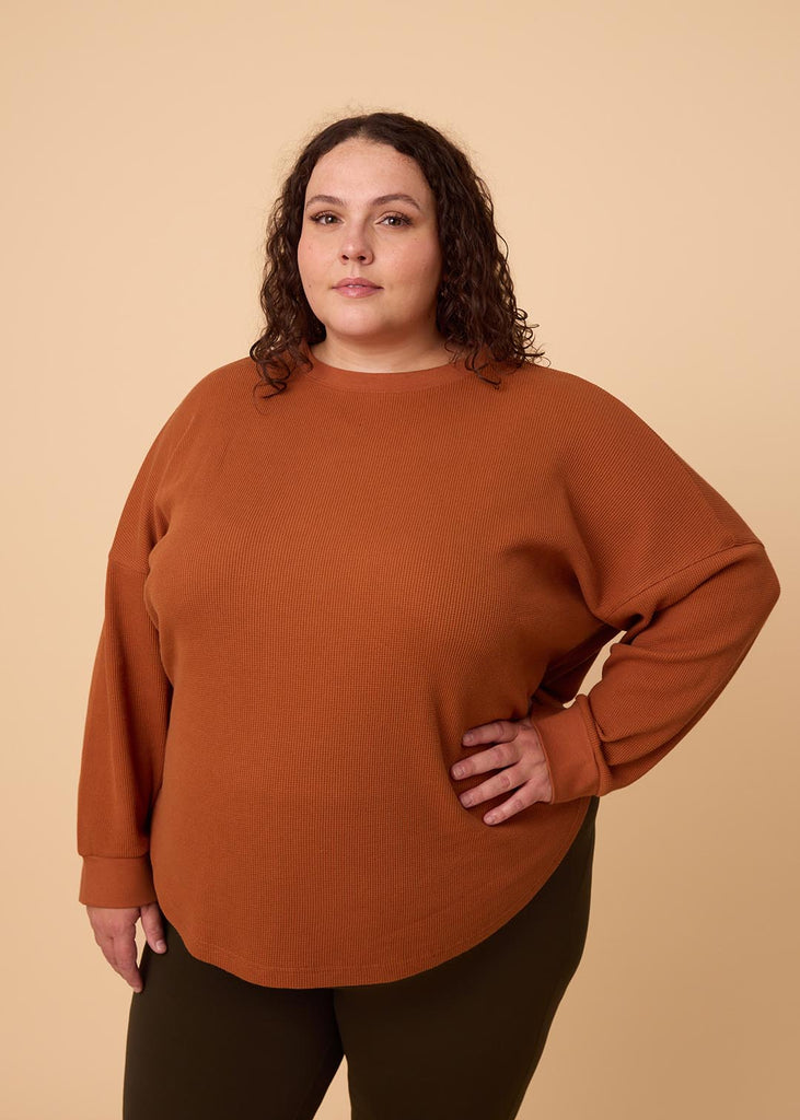 plus size woman wearing orange long sleeve waffle shirt