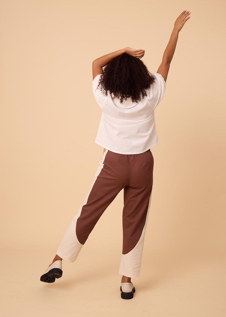 a straight sized woman wearing brown and white pants