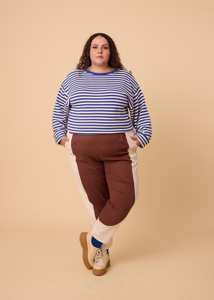 a plus sized woman wearing brown and white pants