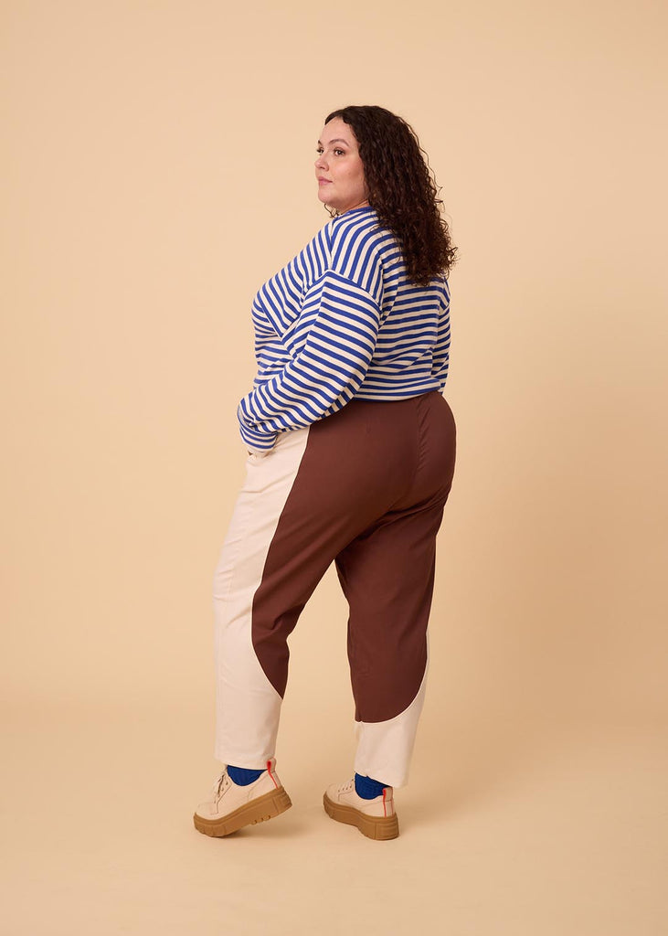 a plus sized woman wearing brown and white pants