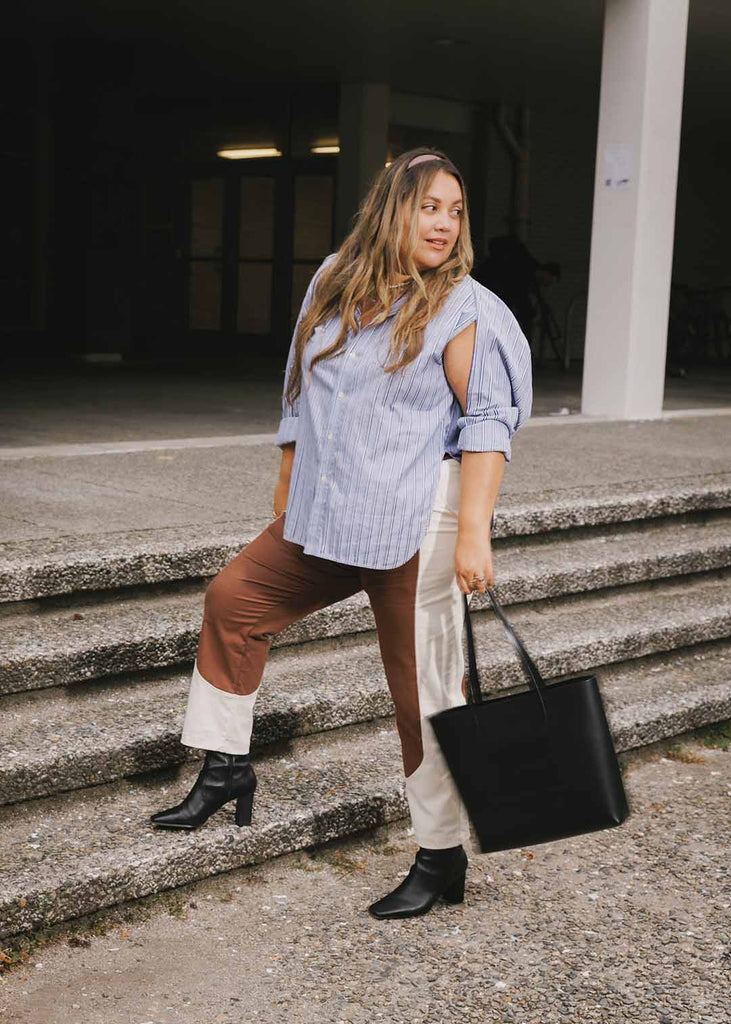 a plus sized woman wearing brown and white pants