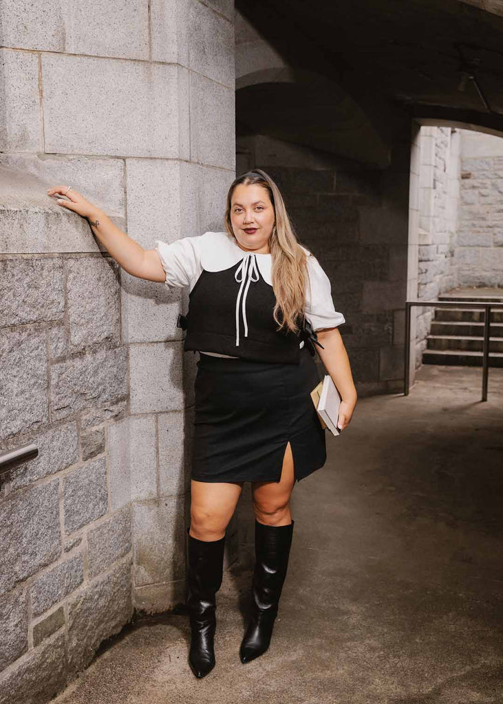 a plus size woman wearing a black miniskirt