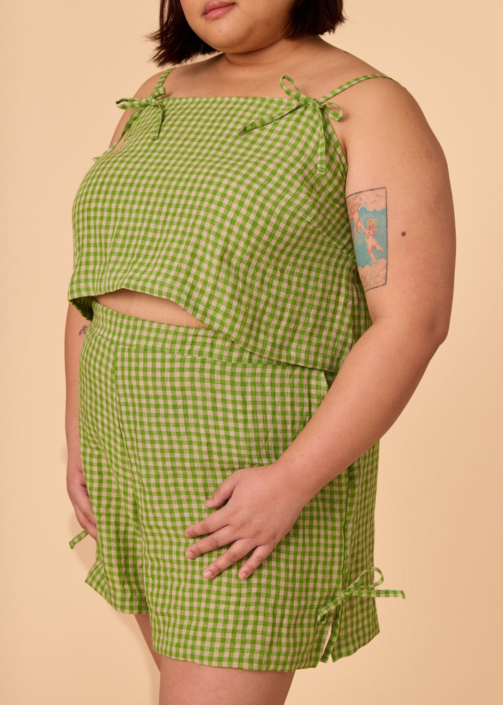 a midsize woman wearing matching lime green gingham shorts and tank top