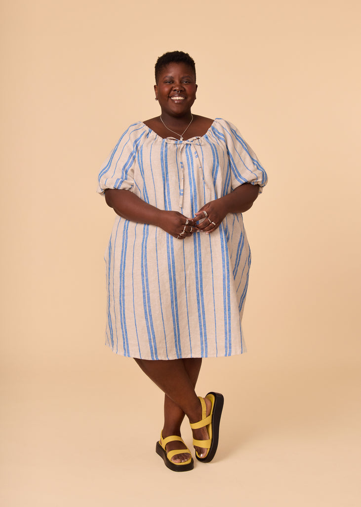 a plus size person wearing a blue striped sundress