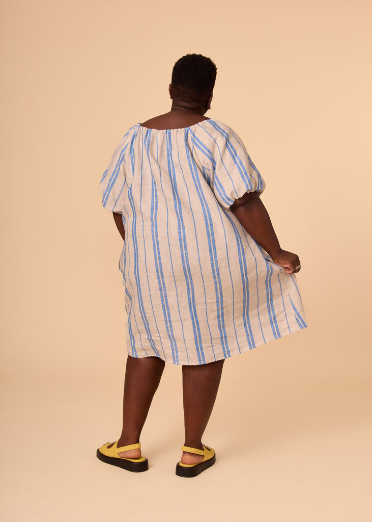 a plus size person wearing a blue striped sundress