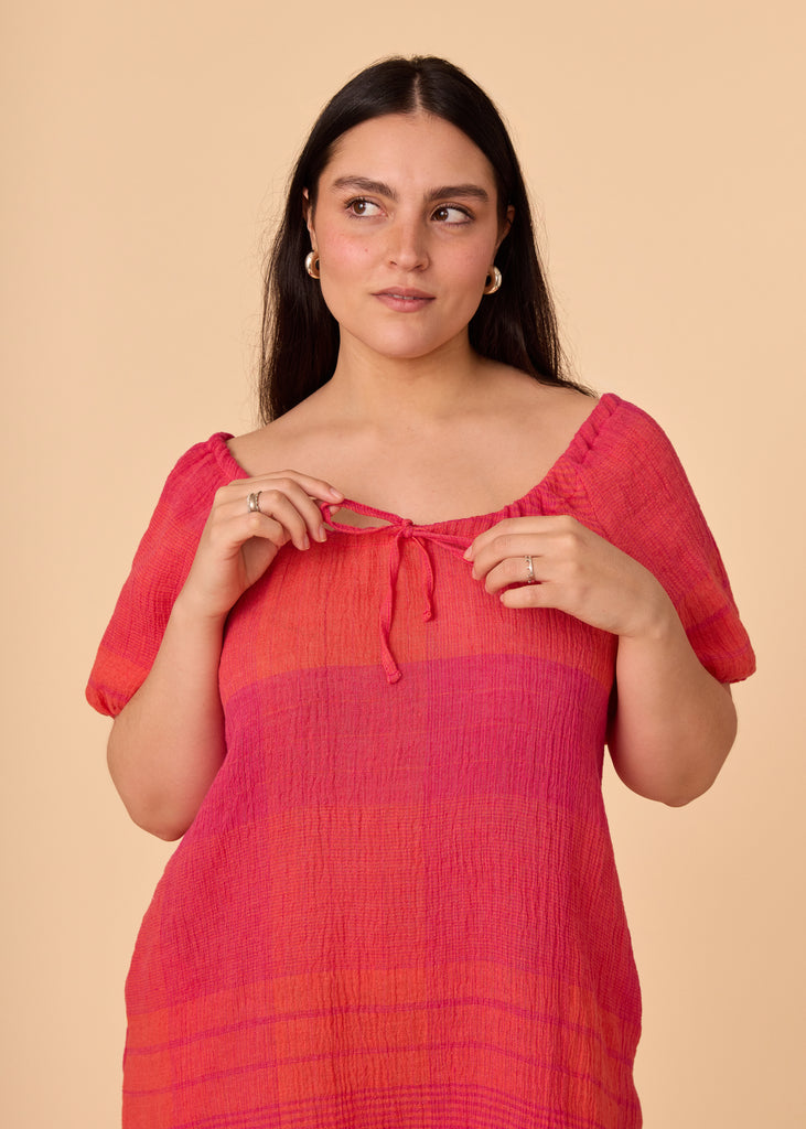 a straight size women wearing a pink and orange sundress