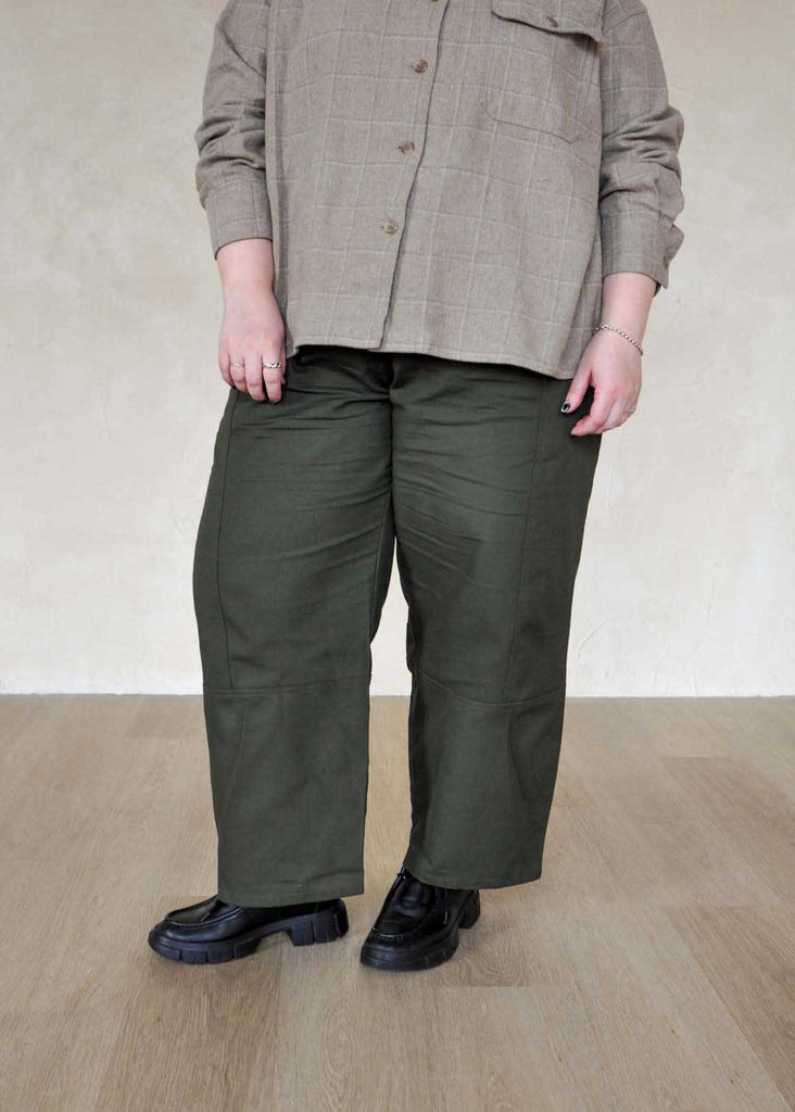 a plus size woman wearing green utility pants