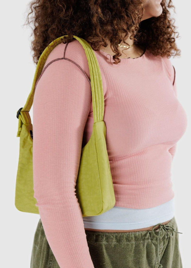 a close up of a person wearing a small green purse on her shoulder