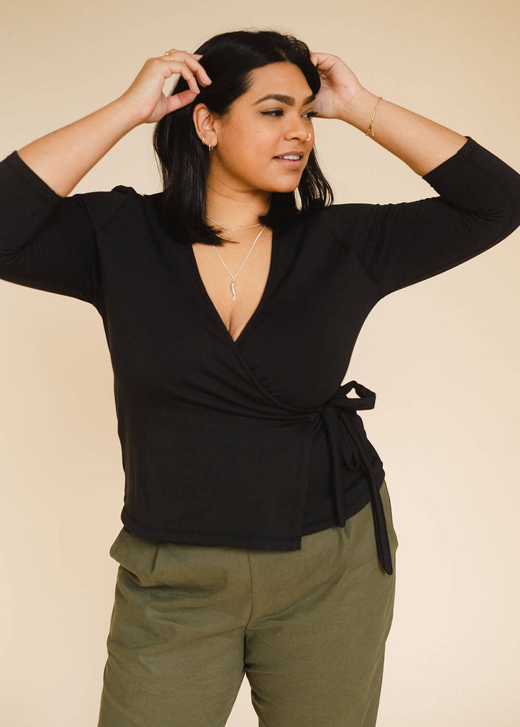 a mid sized woman wearing a black wrap top