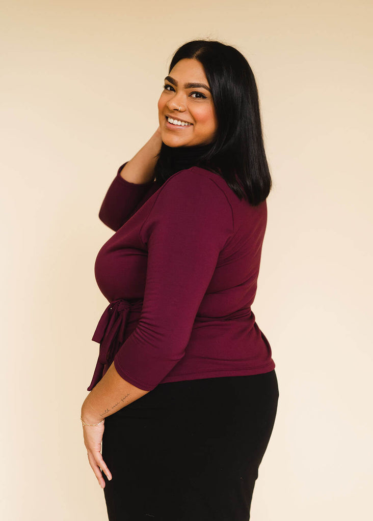 a midsize woman wearing a burgundy wrap top
