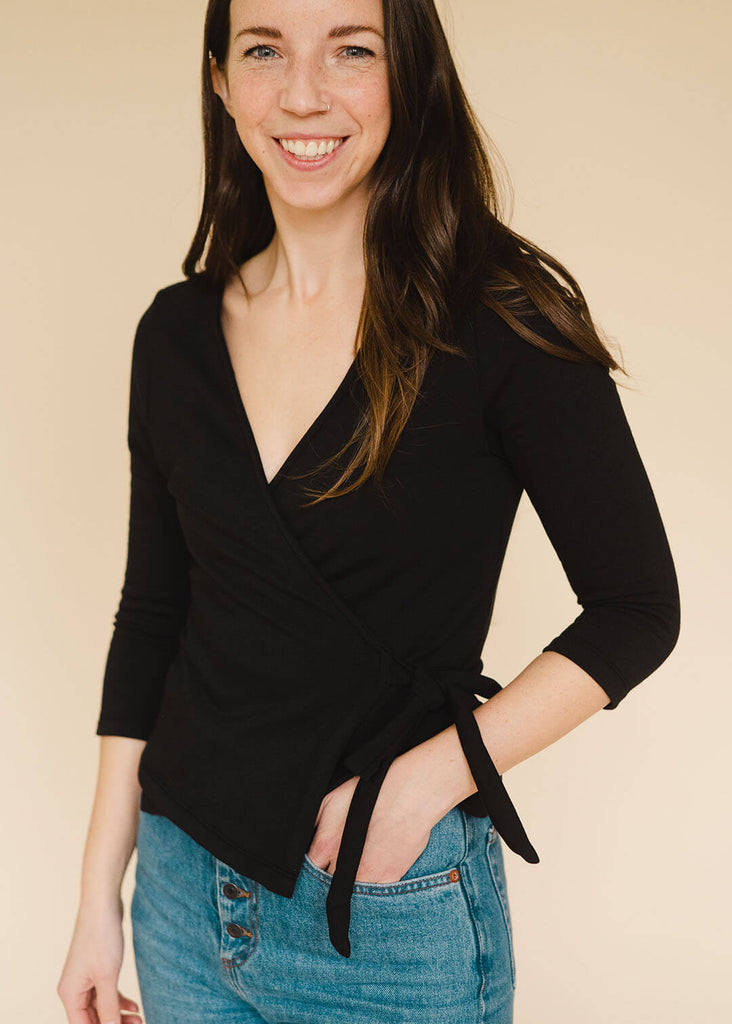 a straight sized woman wearing a black wrap top