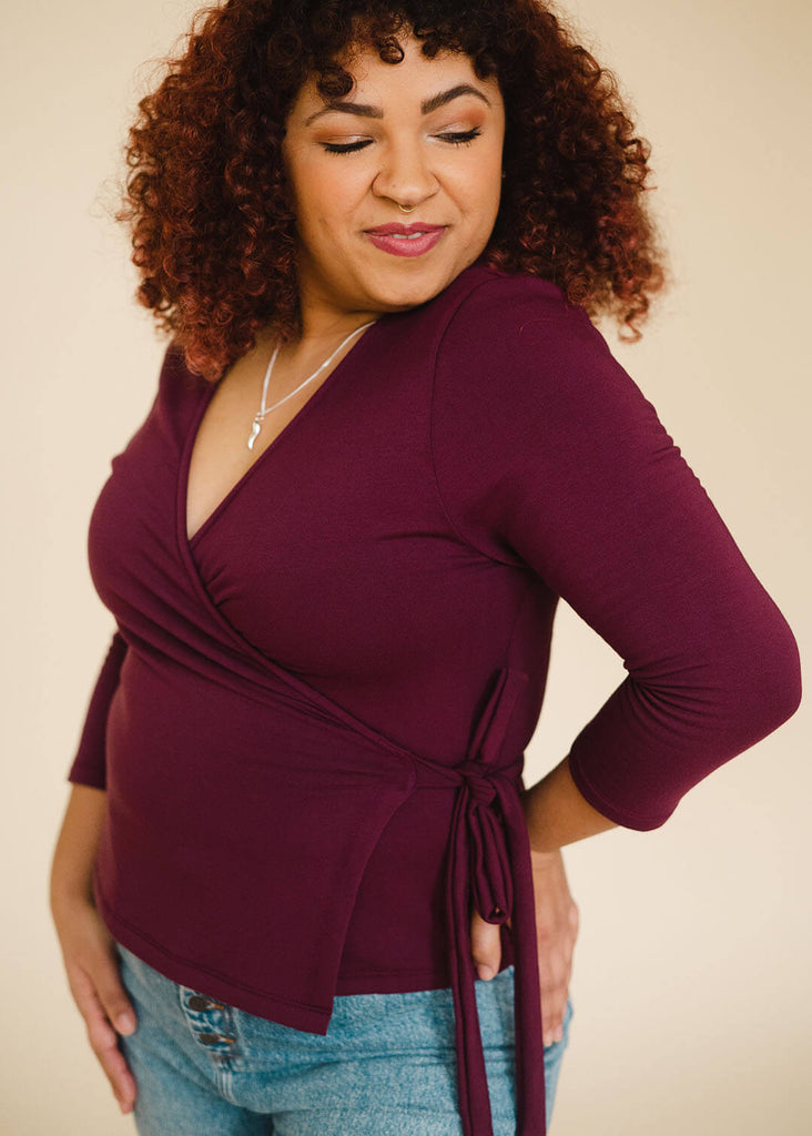 a mid size woman wearing a burgundy wrap top
