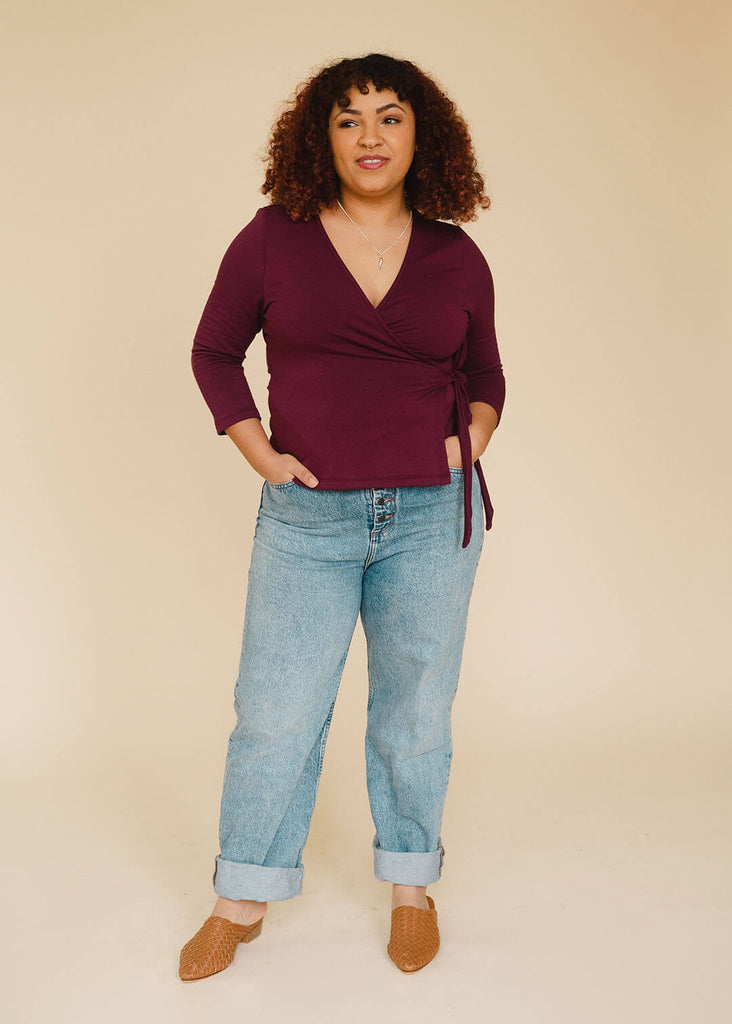 a mid size woman wearing a burgundy wrap top