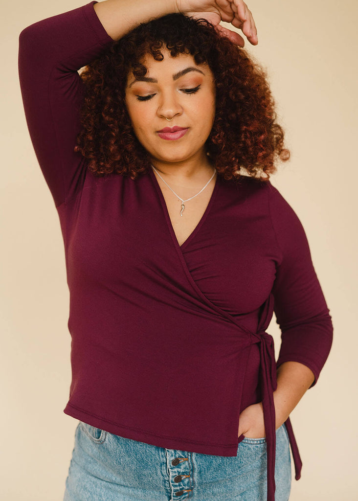 a mid size woman wearing a burgundy wrap top