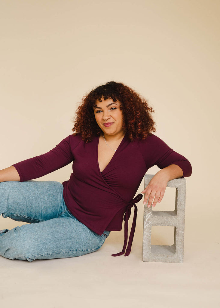 a midsize woman wearing a burgundy wrap top