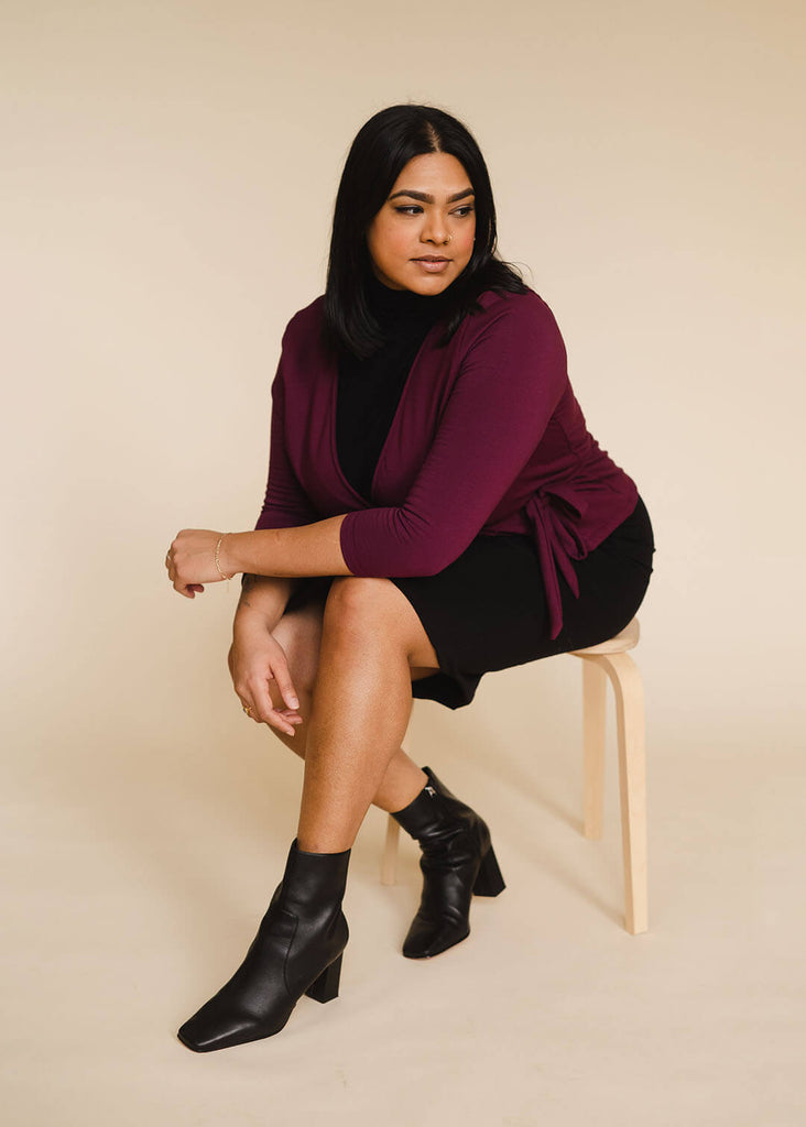a midsize woman wearing a burgundy wrap top