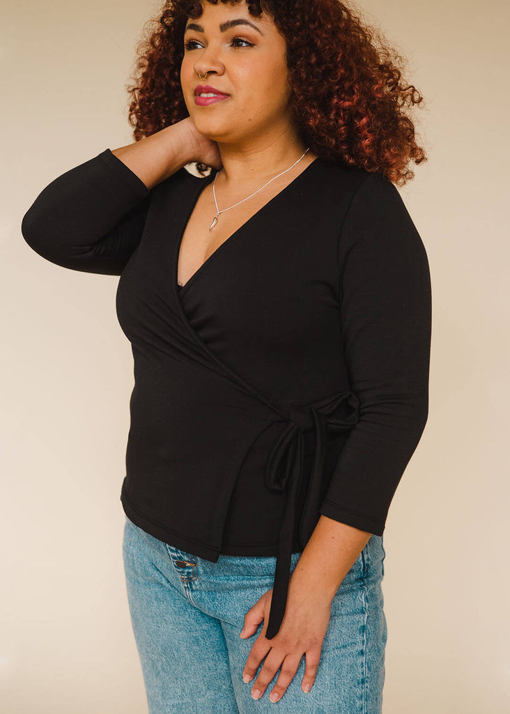 a mid sized woman wearing a black wrap top