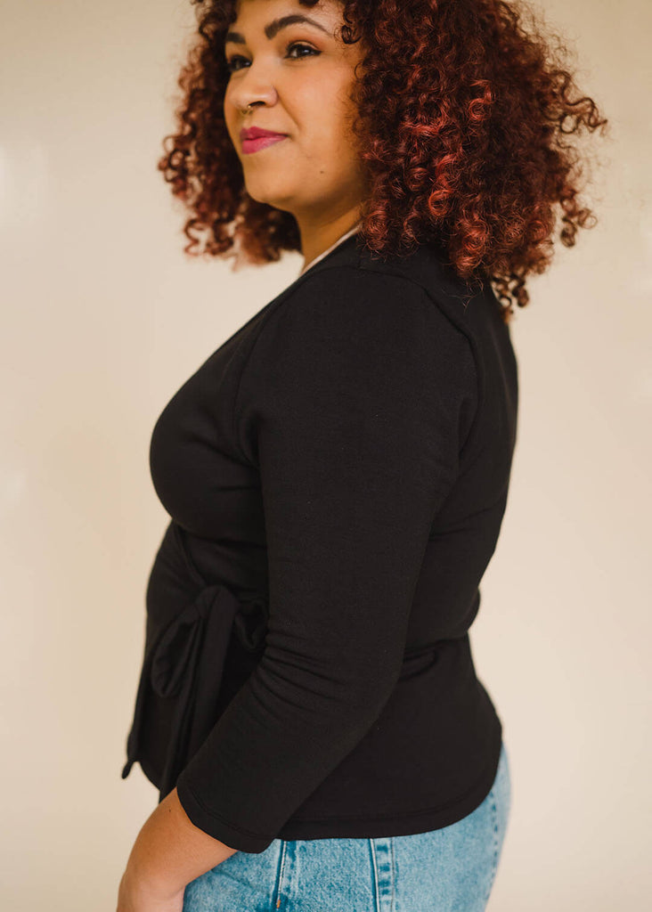 a mid sized woman wearing a black wrap top