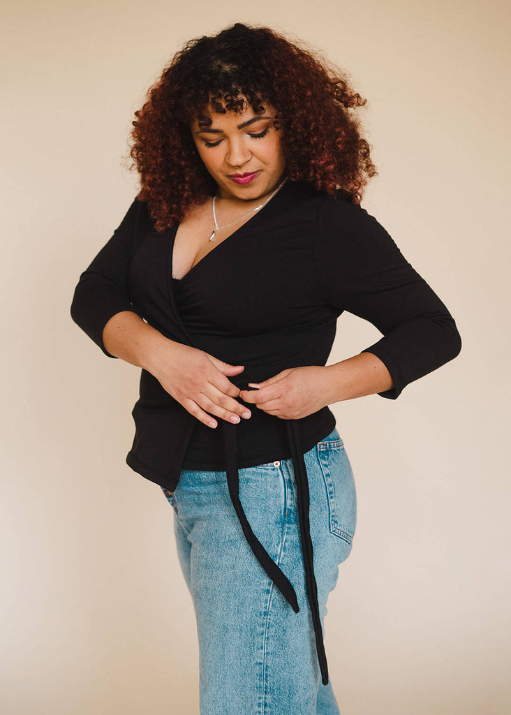 a mid sized woman wearing a black wrap top
